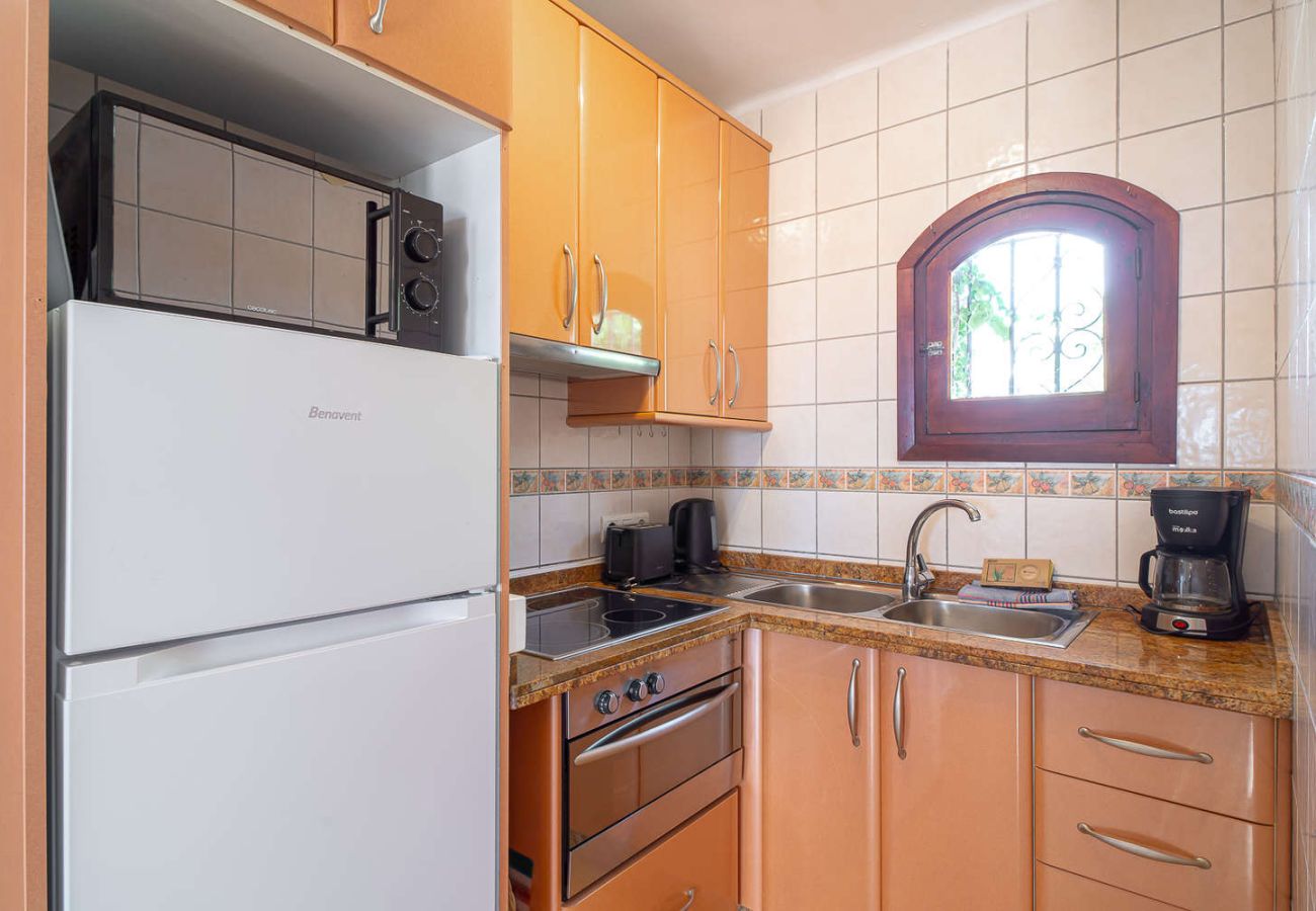 Offene, voll ausgestattete Küche mit Backofen, Mikrowelle und modernen Geräten.