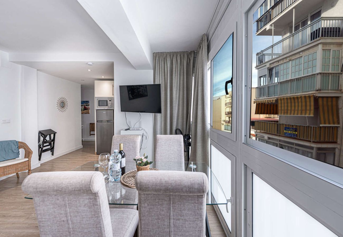 Essbereich mit Glastisch neben einem großen, hellen Fenster in Nerja.