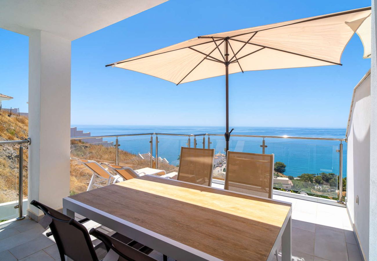Private Terrasse mit Esstisch und Panoramablick auf das Mittelmeer an einem sonnigen Tag in Nerja.